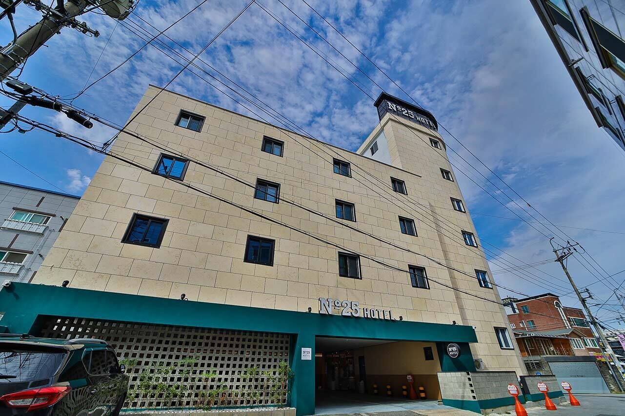Et hotel med flere etager, en flad facade og nummer 25, med en tydelig indgang.