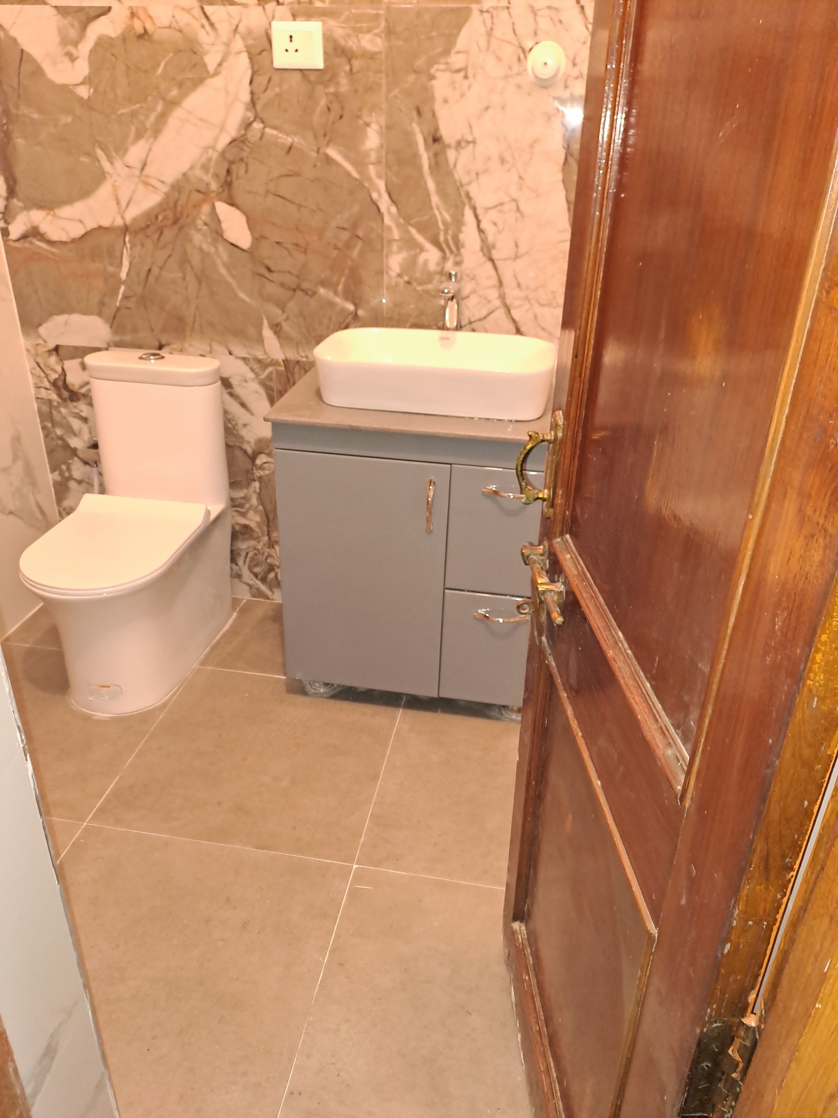 Un baño con inodoro, lavamanos y armario.