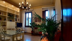 A dining area with a glass table and chairs, surrounded by shelves with books and decorative items. - Spacious apartment in classic style 200 meters from the historical center (Firenze)