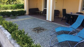 An outdoor seating area with blue lounge chairs, a table, and a bench. - Large 2 bedroom apartment close to swimming pool and beaches (Contrada Difesa II)
