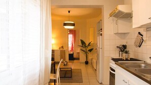 A compact kitchen with a dining area, a potted plant, and a hanging light fixture. - Apartment for 2/3 people - Ney District, Angers (Angers)