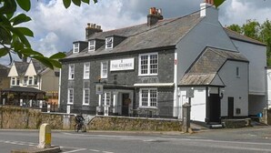 A two-story building with a sign reading "The George." - The George Inn Plympton (Plymouth)