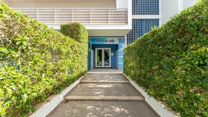 A pathway leading to a building entrance labeled "Edificio-Sol" with a modern architectural design, featuring a blue and white color scheme and a gated entrance. - Bright 1 BDR Flat W/ Pool & Balcony by LovelyStay (Portimão)