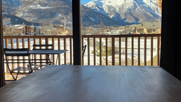 Eine Holterrasse mit Blick auf schneebedeckte Berge.