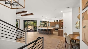A modern interior with a staircase, a dining area, and a kitchen. - Luxury Sedona Sanctuary | Views, Sauna, Fire Pit (Sedona)