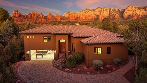 A two-story house with a tiled roof, a patio, and a view of red rock formations. - Luxury Sedona Sanctuary | Views, Sauna, Fire Pit (Sedona)