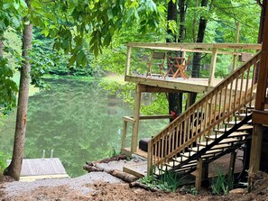 A wooden deck with a staircase leading to a viewing platform over a body of water, surrounded by trees. - Lakeside Cabin: Private Dock - Canoe & Kayaks - HotTub -PetFriendly -Arcade Game (Campton)