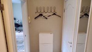 A narrow hallway with a white radiator, a coat rack with several hangers, and a door on the right. - 3-room 2 level family-/pet-friendly apartment in Riga with WiFi and parking (Riga)