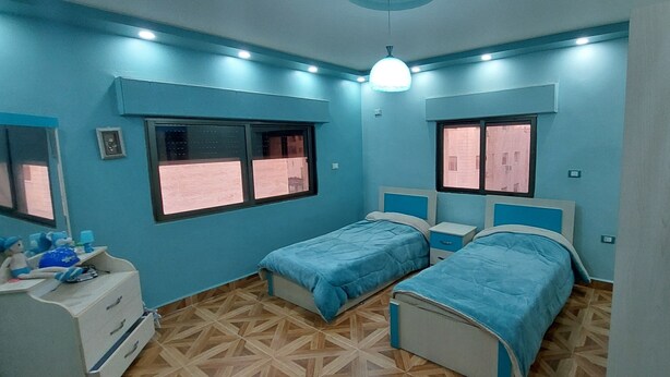 A bedroom with two single beds, a dresser, and a window. - Modern Duplex In the center of Irbid (Irbid)
