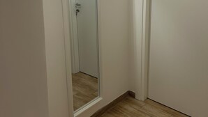 A hallway with a mirrored wall, a door, and a light fixture. - Le Suite di Giordy e Peppe 
4-bedroom apartment in charming Napoli with WiFi, AC (Napoli)