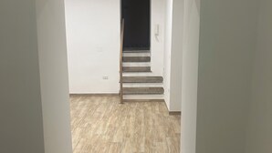 A staircase leading to a dark doorway, with a light switch and a phone on the wall. - Le Suite di Giordy e Peppe 
4-bedroom apartment in charming Napoli with WiFi, AC (Napoli)