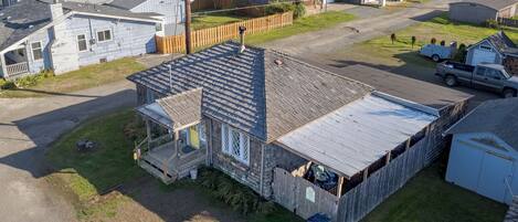 A residential property with a large detached house, a fenced backyard, and a gravel driveway.