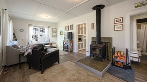 Un salon chaleureux avec une cheminée, un canapé, un téléviseur et un coin repas.