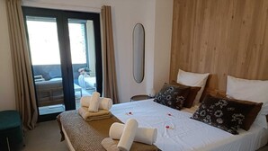 Une chambre d’hôtel avec un grand lit, un banc et une vue sur l’extérieur.