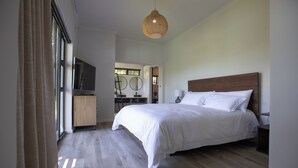 Une chambre à coucher avec un grand lit, une télévision et une armoire en bois.