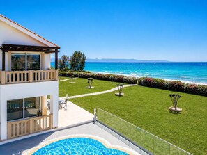 Un immeuble moderne doté d’une piscine, d’un balcon et offrant une vue sur la mer.