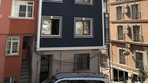 A multi-story building with a dark facade and white-framed windows. - Capricorn by Otantik Suites (Istanbul)