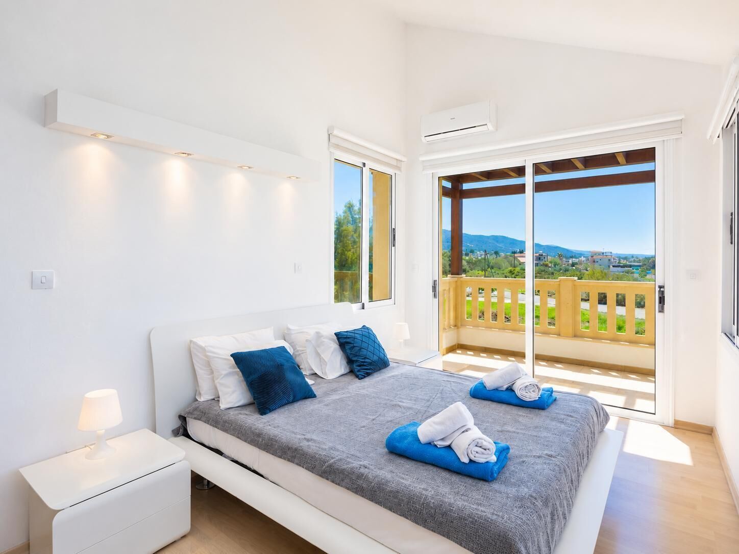 Una camera da letto con un letto, un comodino e vista sull'esterno tramite una porta scorrevole.