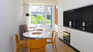 A modern kitchen with a dining area, large windows, and a view of greenery outside. - 801 O "Your Temporary Home (Ciudad Autónoma de Buenos Aires)