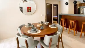A dining area with a round table, chairs, and a ceiling fan.