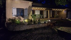A building with a stone foundation, a balcony with plants, and string lights. - THE PROVENCE (Bollène)