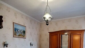 A bedroom with two beds, a wooden wardrobe, a ceiling light fixture, and a framed picture on the wall. - THE PROVENCE (Bollène)