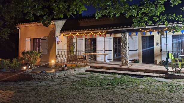 A building with a patio area, outdoor seating, and string lights. - THE PROVENCE (Bollène)
