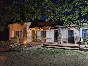 A building with a patio area, outdoor seating, and string lights.
