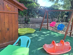 A wooden play structure with a swing set and plastic seating. - THE PROVENCE (Bollène)