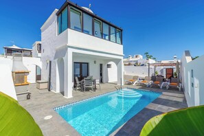 Une villa moderne dotée d’une piscine sur le toit, d’un espace salon extérieur et d’un patio couvert.