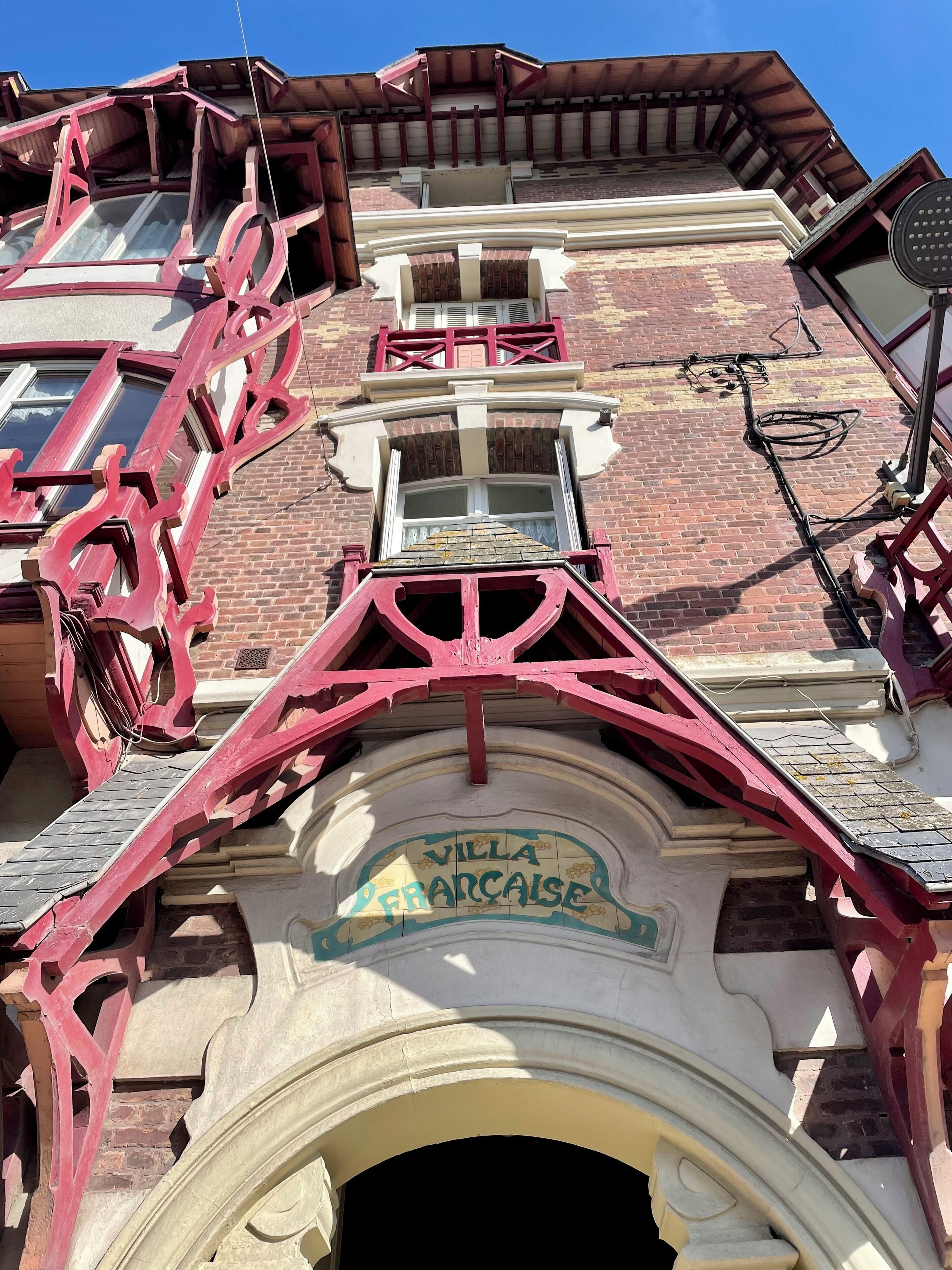 A building with a prominent archway labeled "Villa Francaise" and a staircase leading to an upper level.