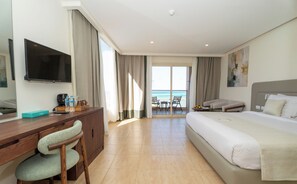 A hotel room with a bed, desk, chair, television, and a view of the sea. - SUNRISE Solara Aqua park Resort (Hurghada)