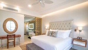 Un dormitorio moderno con una cama grande, mesitas de noche, un escritorio y una silla.