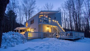 A two-story house with a balcony, surrounded by snow and trees. - 3-Bedroom 2 Bath Cozy Chalet 1 Mile From Mountain! (Lanesville)