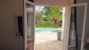 Un dormitorio con una puerta corrediza de vidrio que da a una zona de piscina.