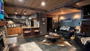 A cozy living room with a fireplace, a bar area, and a dining space. - Peach Jam Luxury Gentleman's Retreat ~ 5 BR BA One of a kind find! (North Augusta)