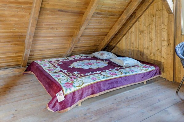 A small, cozy room with a wooden ceiling and a single bed with a floral bedspread. - Chalet in Liberec Near Ski Resort Jested (Svetla pod Jestedem)