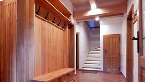 A wooden hallway with a bench, a coat rack, and a staircase leading to another room. - Villa Near Horni Domky Ski Resort (Rokytnice nad Jizerou)