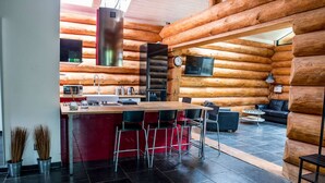 A log cabin interior with a kitchen, dining area, and living space. - Villa in Lomnice nad Popelkou (Lomnice nad Popelkou)