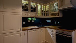 A kitchen with white cabinets, a wooden countertop, and a built-in oven.