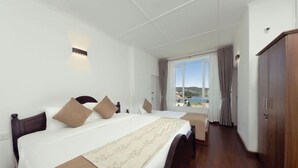 Une chambre d’hôtel avec un grand lit, une armoire en bois et une fenêtre donnant sur un beau paysage.