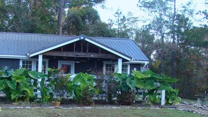 A two-story house with a dark exterior, a gabled roof, and a front porch with a white railing. - Charming 2 bedroom home in Tallassee, Alabama near Lake Martin (Tallassee)