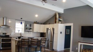 A modern kitchen with white cabinets, stainless steel appliances, and a built-in island with bar stools. - Charming 2 bedroom home in Tallassee, Alabama near Lake Martin (Tallassee)
