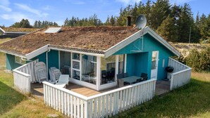 A small, single-story house with a sloped roof, a deck, and a satellite dish. - 5 Star Holiday Home in Blokhus (Blokhus)