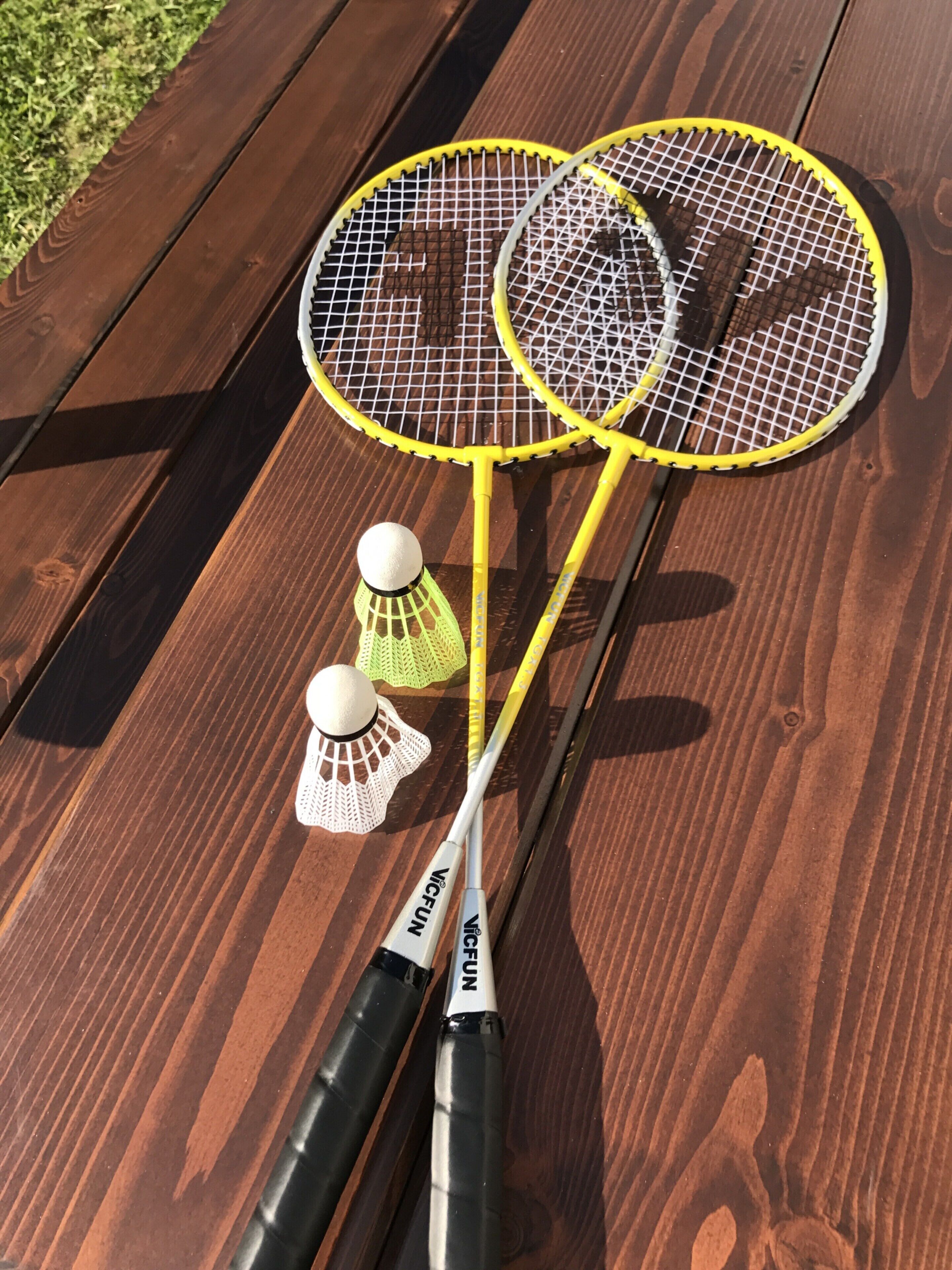 Raquetas de bádminton y volantes sobre una mesa de madera.
