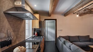 A modern kitchen with a built-in oven, a coffee machine, and a bread loaf on the counter. - Chalet in Horni Marsov Near Ski Slopes (Horni Marsov)