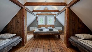 A bedroom with a sloped ceiling, wooden beams, a central bed with two pillows, and two bedside tables. - Chalet in Horni Marsov Near Ski Slopes (Horni Marsov)