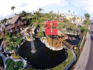 A water feature with a castle-like structure, a small pool, and surrounding greenery.