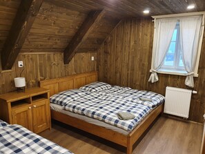 A wooden room with a bed, a nightstand, and a window with curtains. - Amazing Villa Near Horni Marsov ski Area (Horni Marsov)