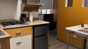 A compact kitchen with a gas stove, microwave, and a small refrigerator. - Charming 1-bedroom apartment in marvelous Monterrey with AC, WiFi (Monterrey)